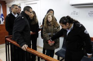 Sixteen-year-old Ahed Tamimi (C) arrives for a hearing in the military court at Ofer military prison in the West Bank village of Betunia on January 1, 2018.  Israeli authorities are seeking 12 charges against Ahed  after a video of her slapping and kicking two Israeli soldiers in the West Bank went viral, her lawyer said. / AFP PHOTO / Ahmad GHARABLI